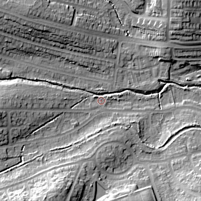 Shaded relief map of the ground around B295SL, computed from Environment Agency LiDAR. The ground here sits at about 135 m above sea level and falls 25 m across the surrounding 800 m. Surface water reaching this point runs off ground lying to the south-south-west, 21.7 m higher.