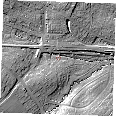 Shaded relief map of the ground around BN265AG, computed from Environment Agency LiDAR. The ground here sits at about 12 m above sea level and falls 15 m across the surrounding 800 m. Surface water reaching this point runs off ground lying to the west, 10.2 m higher.
