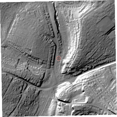 Shaded relief map of the ground around EX13DG, computed from Environment Agency LiDAR. The ground here sits at about 18 m above sea level and falls 38 m across the surrounding 800 m. Surface water reaching this point runs off ground lying to the north-east, 33.4 m higher.