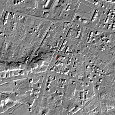 Shaded relief map of the ground around GL502QE, computed from Environment Agency LiDAR. The ground here sits at about 65 m above sea level and falls 16 m across the surrounding 800 m. Surface water reaching this point runs off ground lying to the south-east, 9.4 m higher.