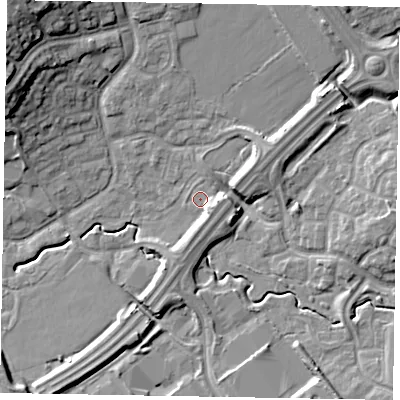 Shaded relief map of the ground around MK77AU, computed from Environment Agency LiDAR. The ground here sits at about 69 m above sea level and falls 18 m across the surrounding 800 m. Surface water reaching this point runs off ground lying to the south-east, 3.3 m higher.