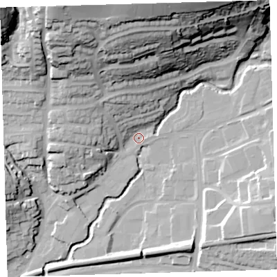 Shaded relief map of the ground around PL74AT, computed from Environment Agency LiDAR. The ground here sits at about 12 m above sea level and falls 57 m across the surrounding 800 m. Surface water reaching this point runs off ground lying to the north, 52.4 m higher.