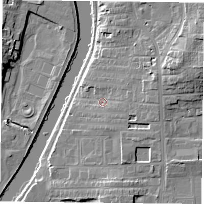 Shaded relief map of the ground around YO104DL, computed from Environment Agency LiDAR. The ground here sits at about 12 m above sea level and falls 16 m across the surrounding 800 m. Surface water reaching this point runs off ground lying to the east, 4.8 m higher.